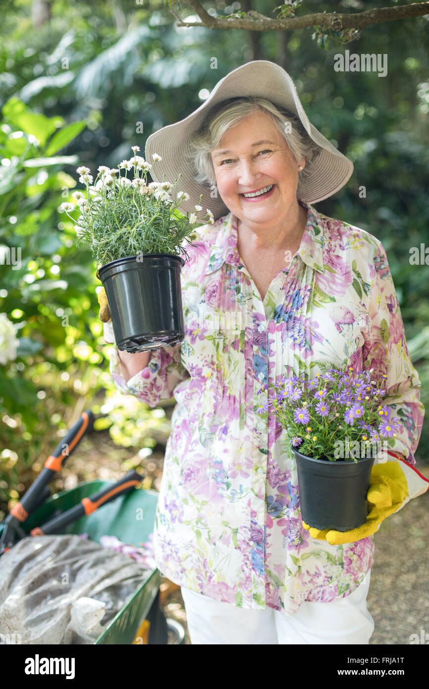 Porträt von senior Frau hält Topfpflanzen Stockfoto