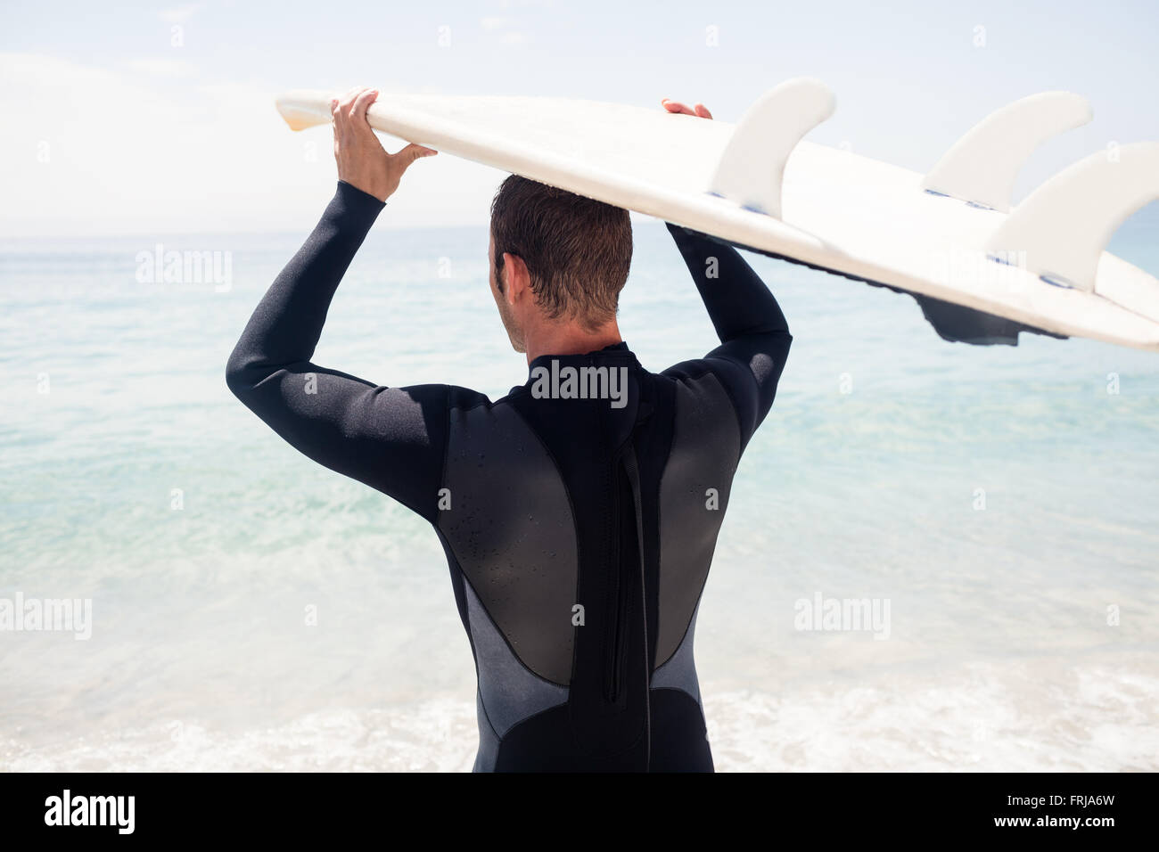 Ansicht der Rückseite des Surfer, Surfbrett über Kopf Stockfoto