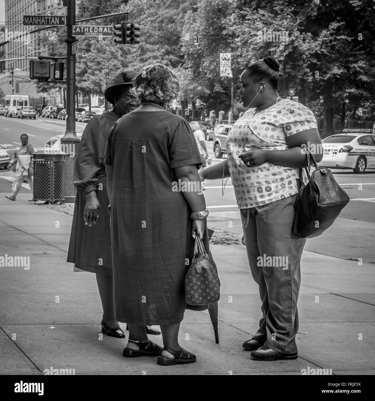 Ein ehrliches Bild von drei afro-amerikanischen Frauen, die sich auf der Straße in New York City, USA, unterhalten. Stockfoto