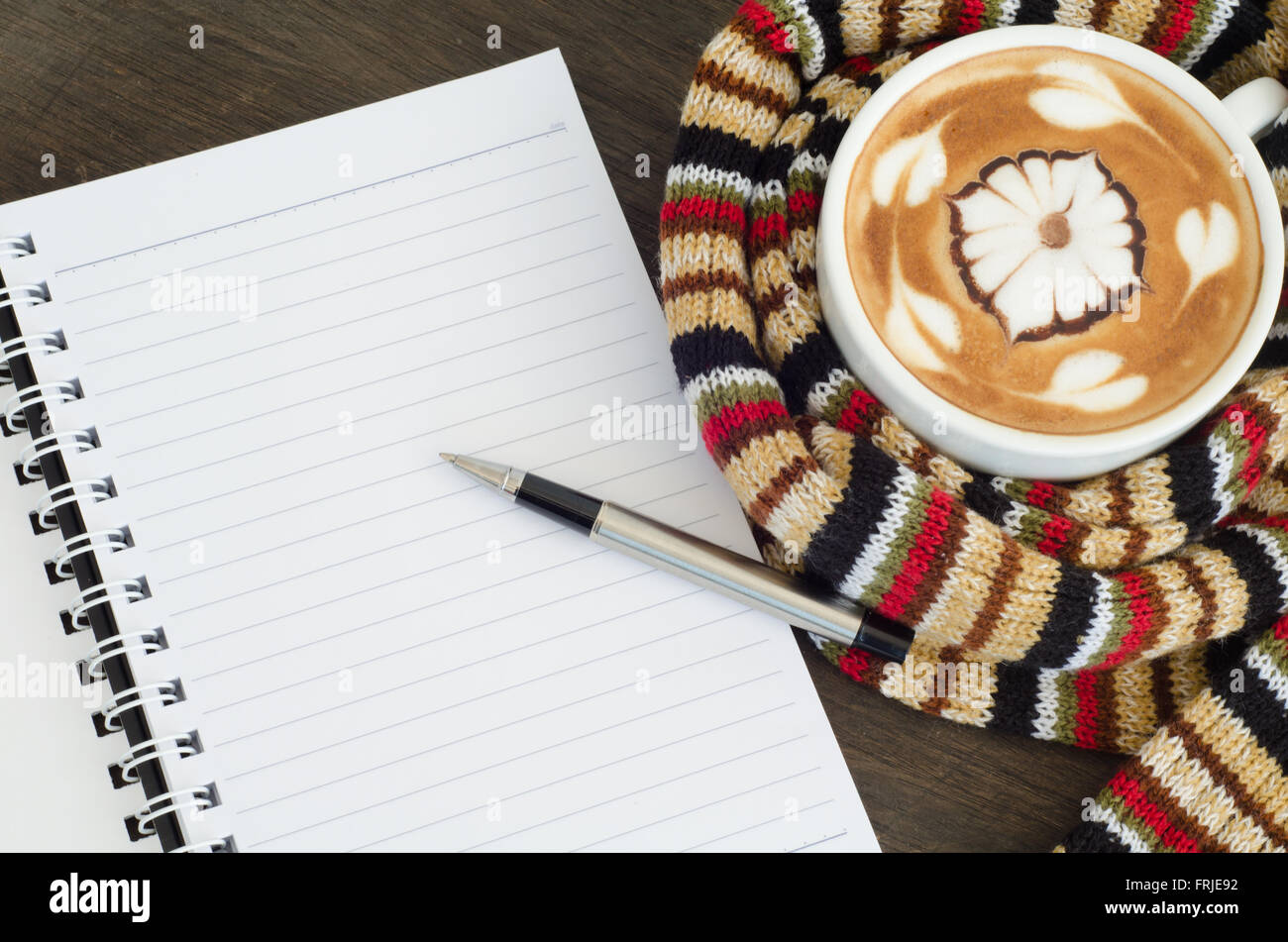 Tasse Kaffee umgeben das warme Schal und Hinweis-Buch Stockfoto