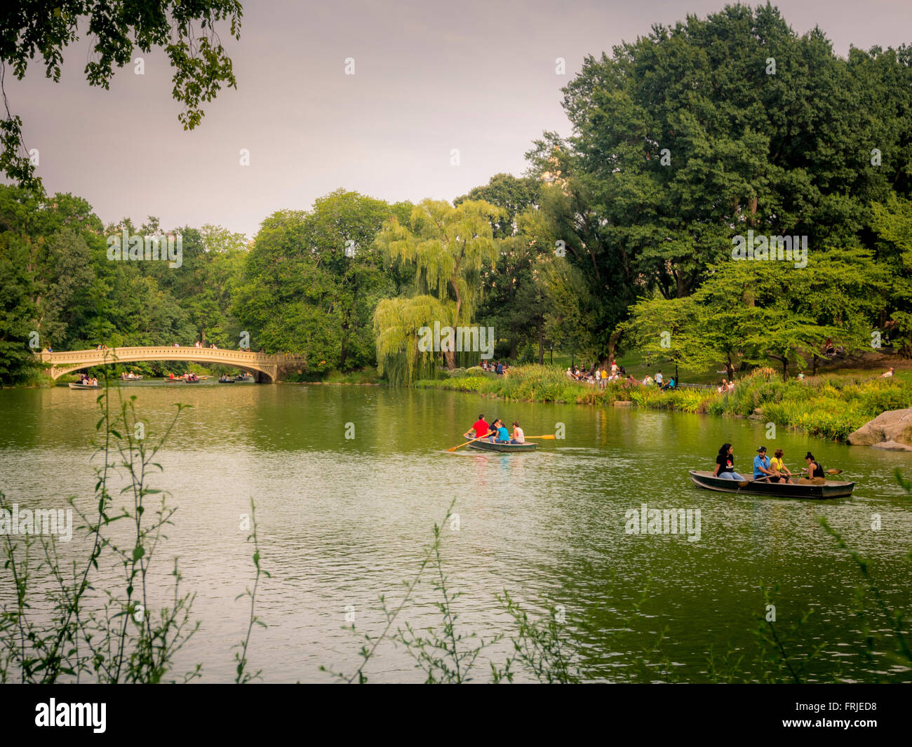 Ruderboote auf dem See, Central Park, New York City, USA. Bow Bridge im Hintergrund Stockfoto