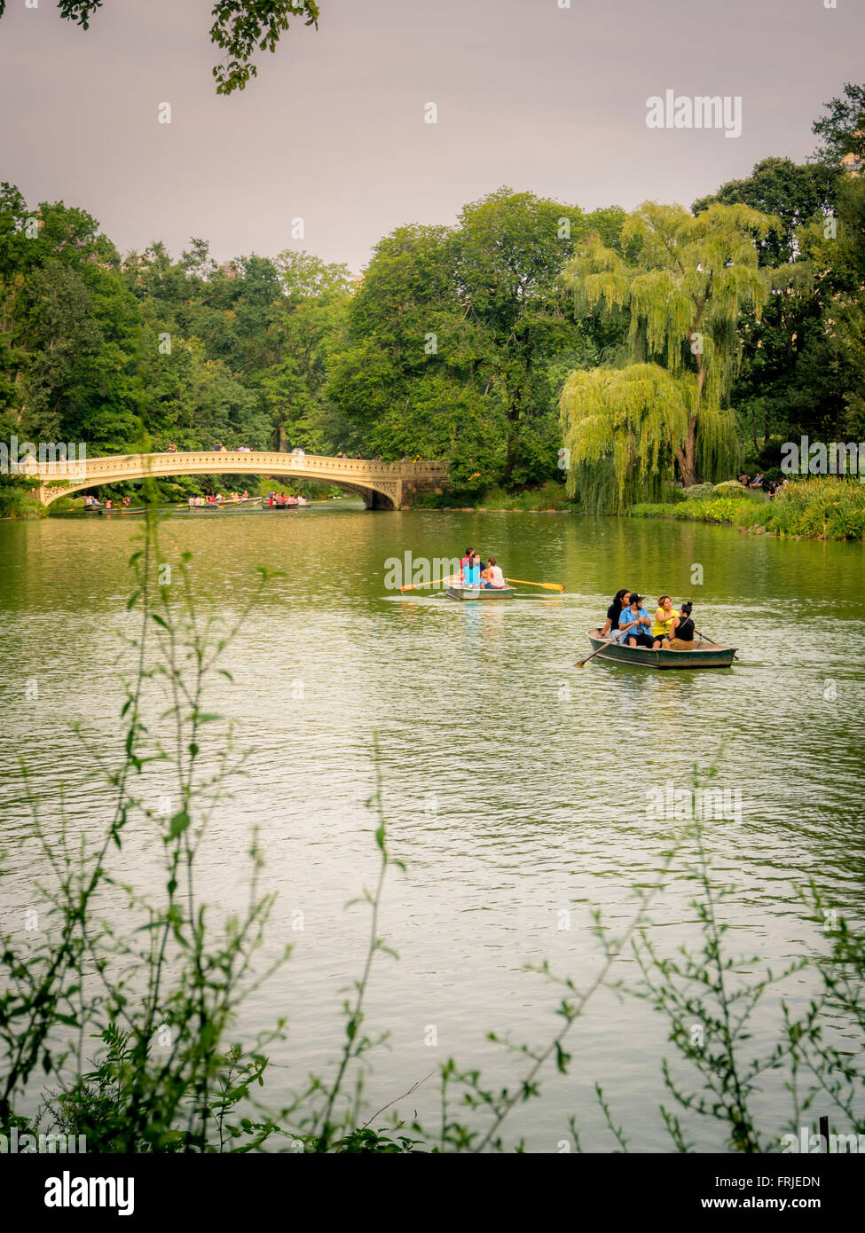 Ruderboote auf dem See, Central Park, New York City, USA. Bow Bridge im Hintergrund Stockfoto