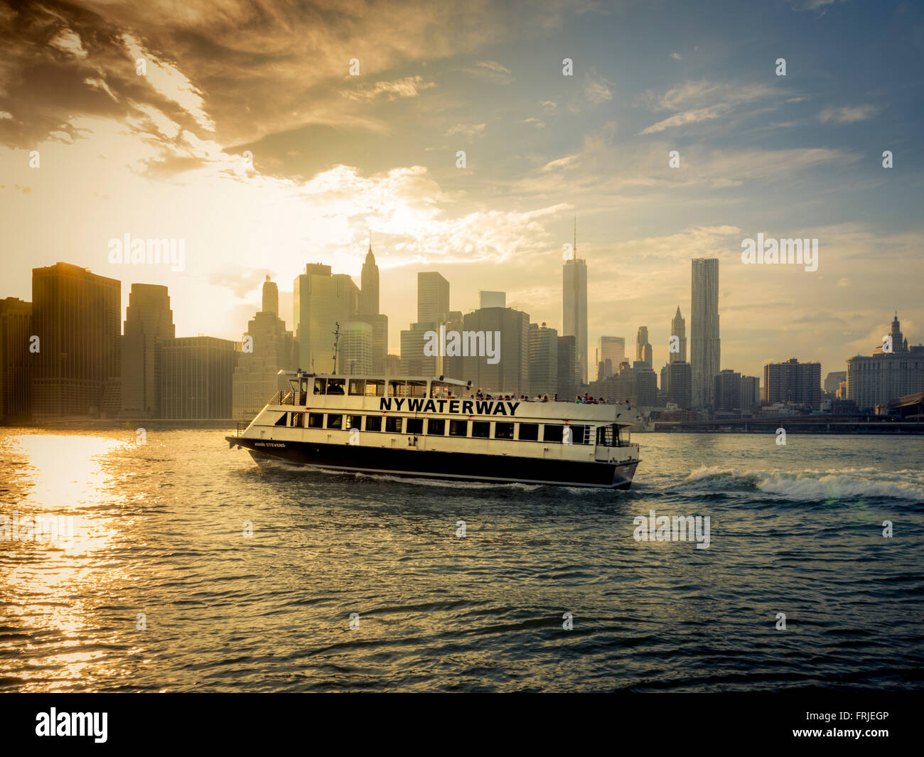 NY Waterway Boot mit Lower Manhattan im Hintergrund auf dem East River, New York, USA Stockfoto