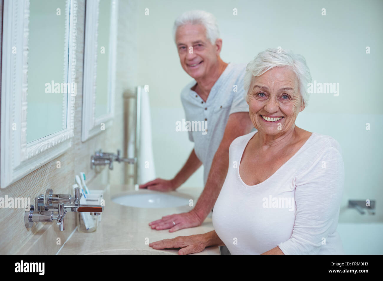 Älteres paar tatenlos Spiegel im Badezimmer Stockfoto