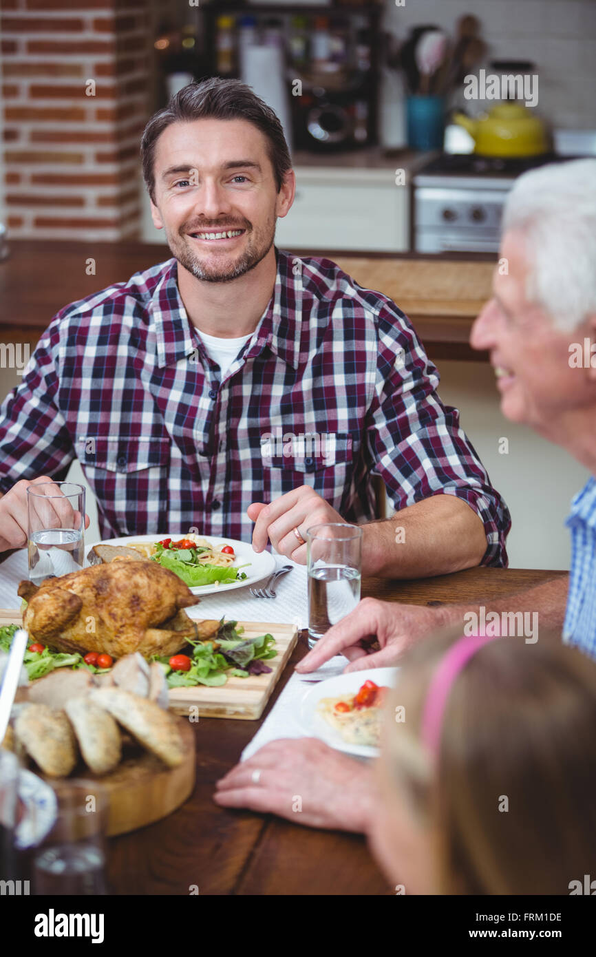Lächelnden Vater sitzen am Esstisch Stockfoto
