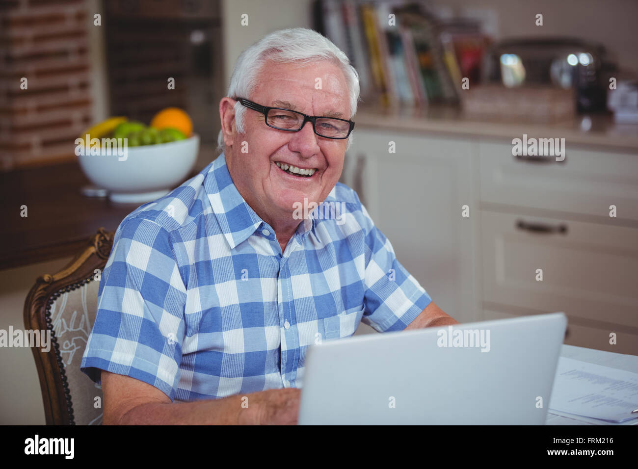 Portrait von lächelnden pensionierter Mann mit laptop Stockfoto