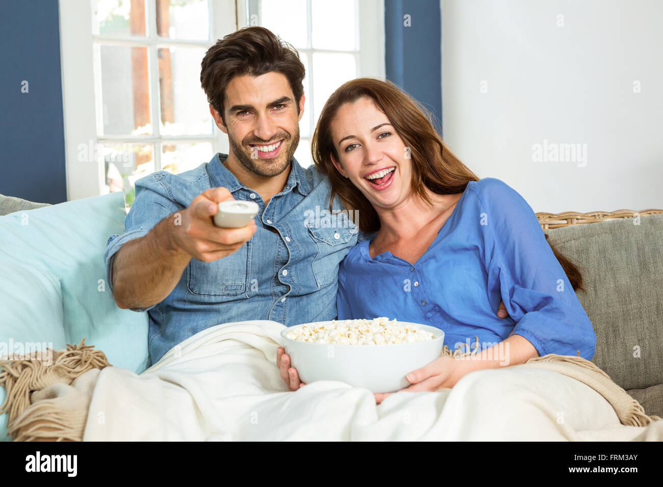 Junges Paar mit Popcorn beim Fernsehen Stockfoto