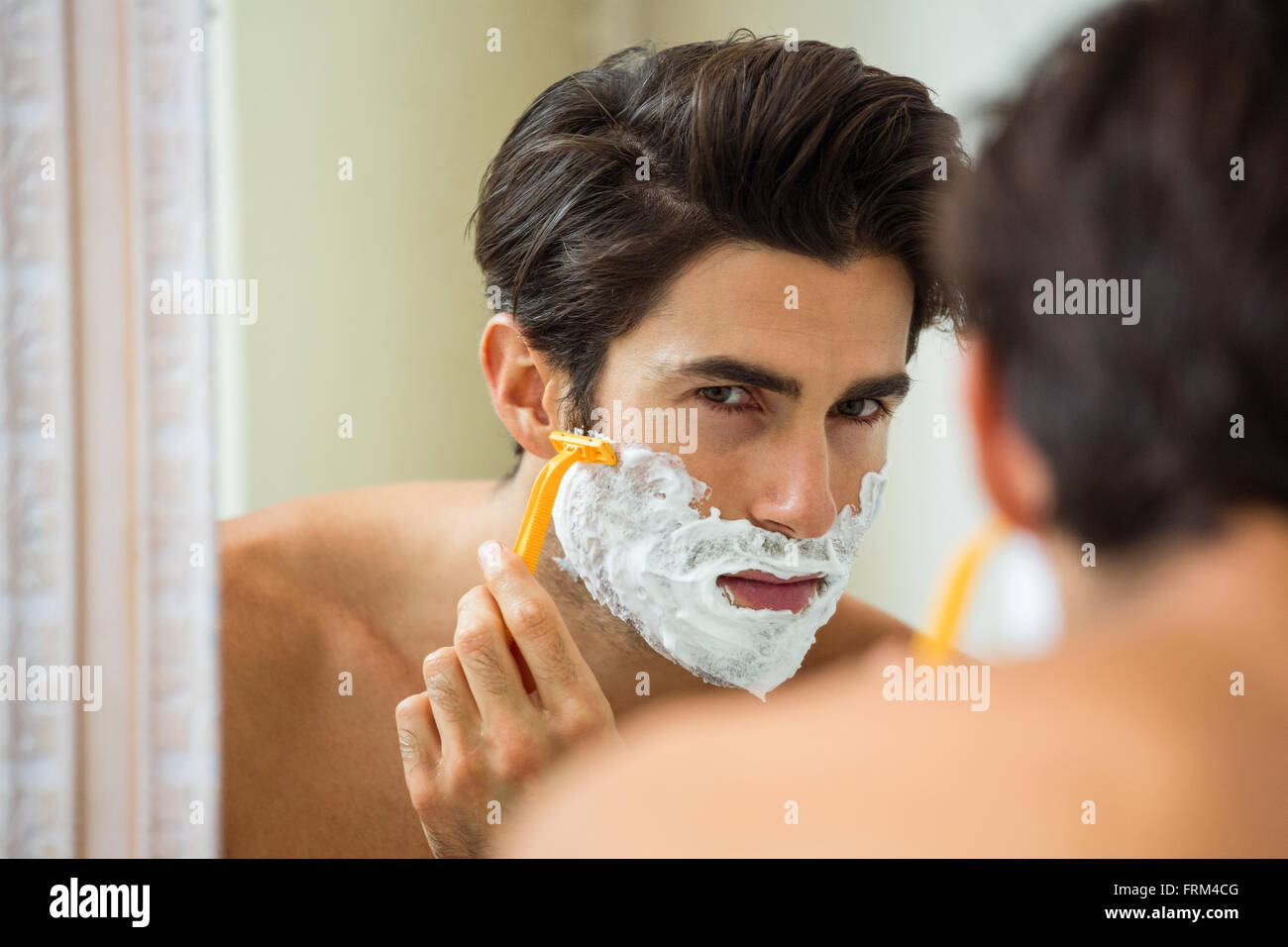 Mann reflektieren, Spiegel während der Rasur seinen Bart Stockfoto