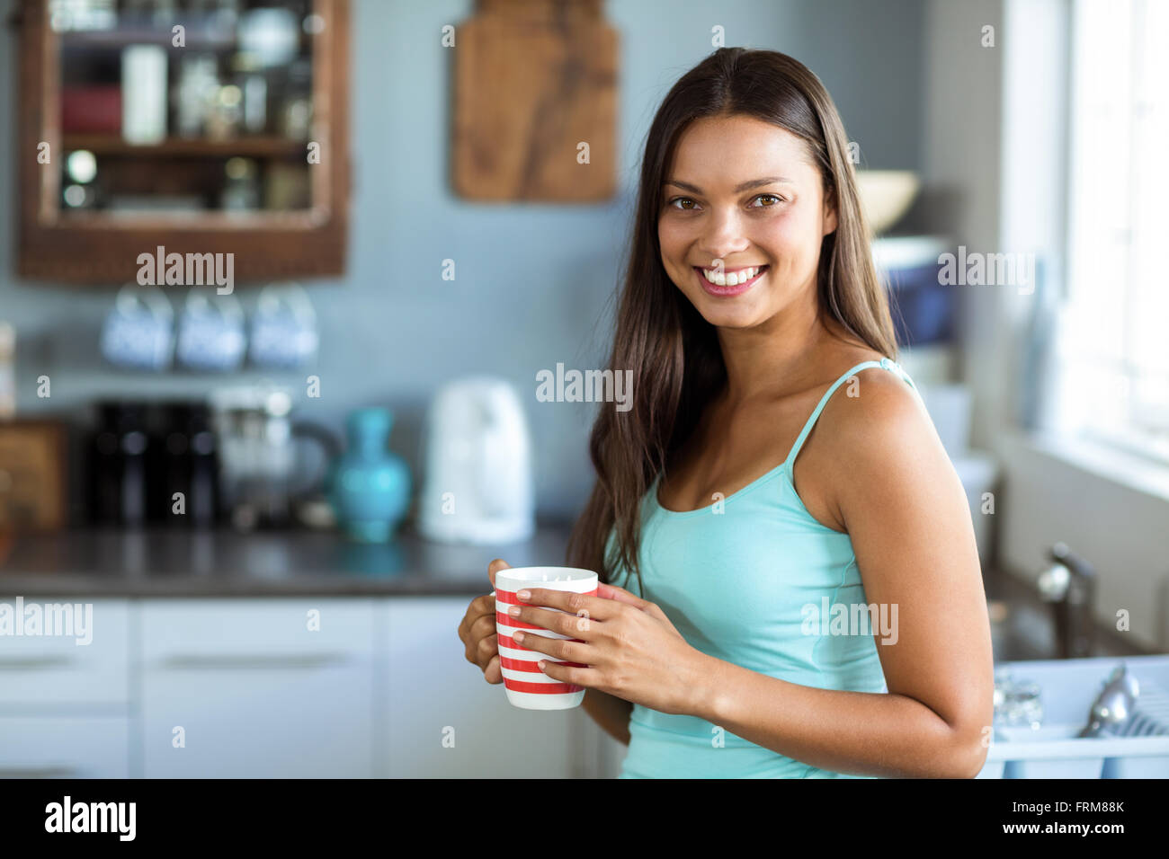 Portrait von lächelnden jungen Frau mit Kaffee Tasse Stockfoto