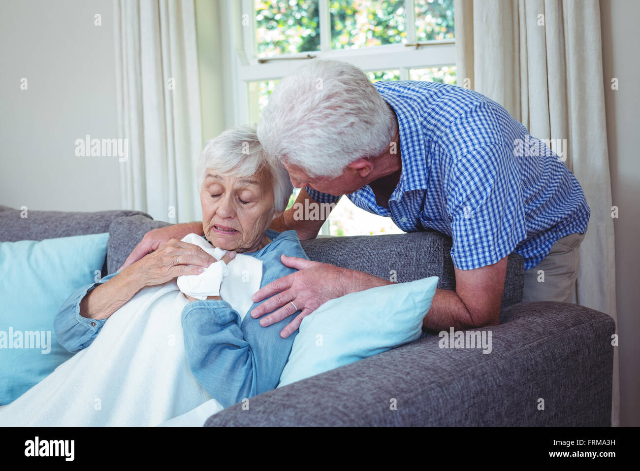 Ältere Mann im Gespräch mit kranken Frau sitzt auf dem sofa Stockfoto