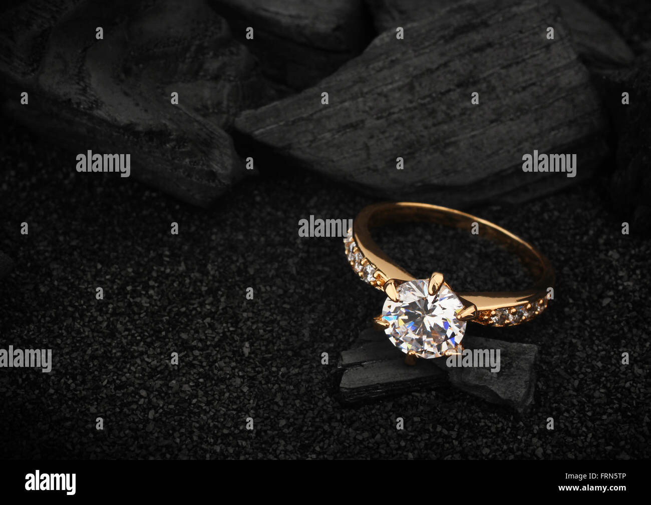 Schmuck Ring mit großen Diamanten auf dunklen Kohle und schwarzem sand Stockfoto