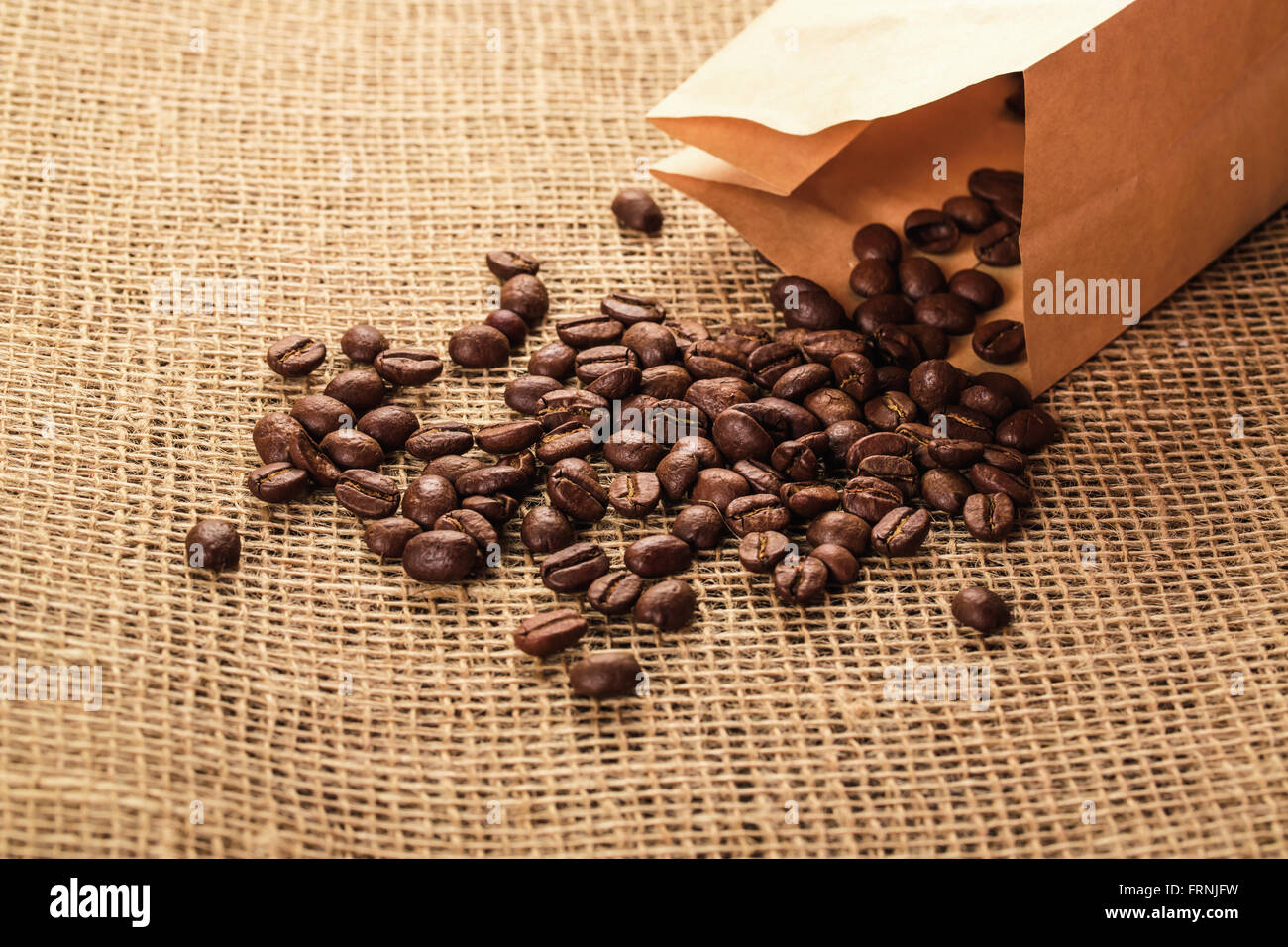 Schöne Kaffeebohnen aus einer Papiertüte ma Sackleinen. schönen Hintergrund für Ihre Ideen Stockfoto