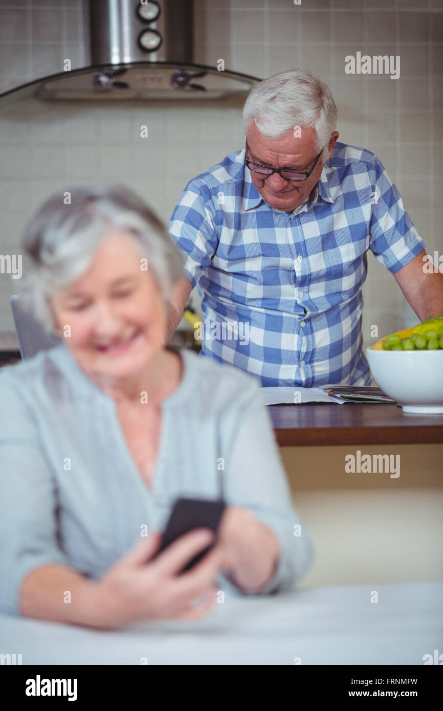 Senior Woman im Hintergrund stehen am Küchentisch Stockfoto