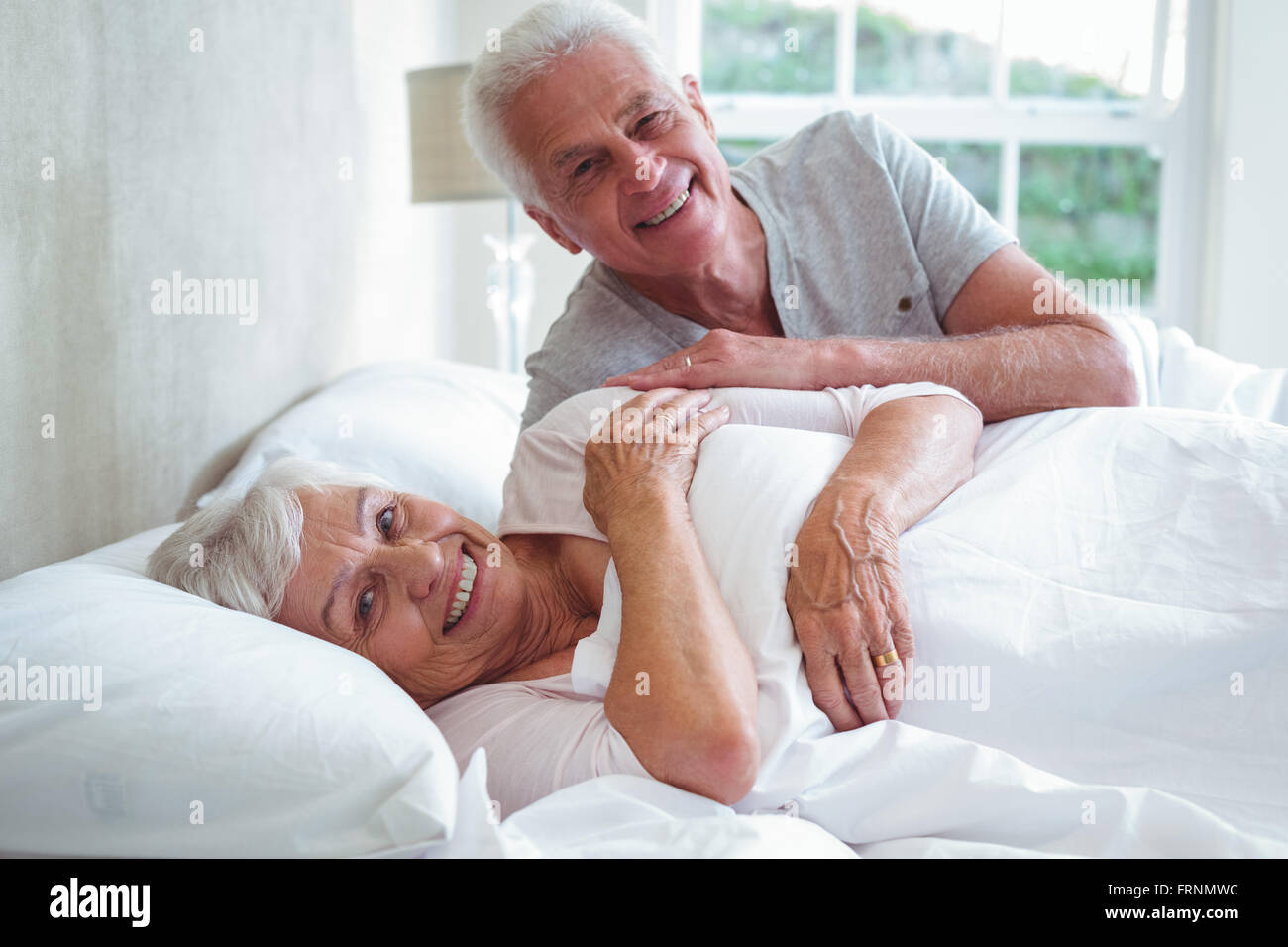 Porträt des Lächelns älteres paar entspannende auf Bett Stockfoto