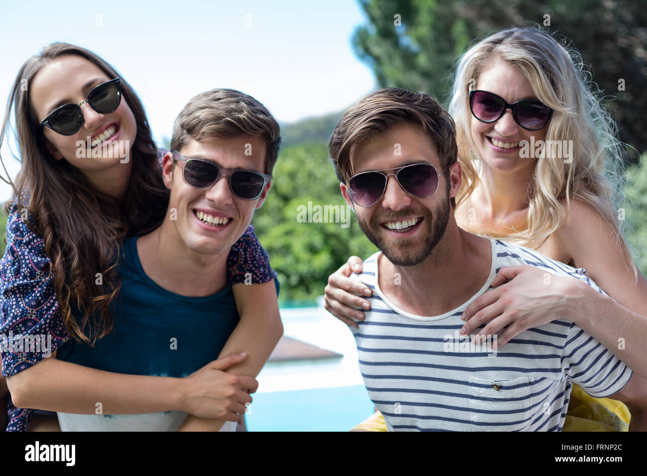 Zwei Männer ein Schweinchen zurück zu Frauen Stockfoto