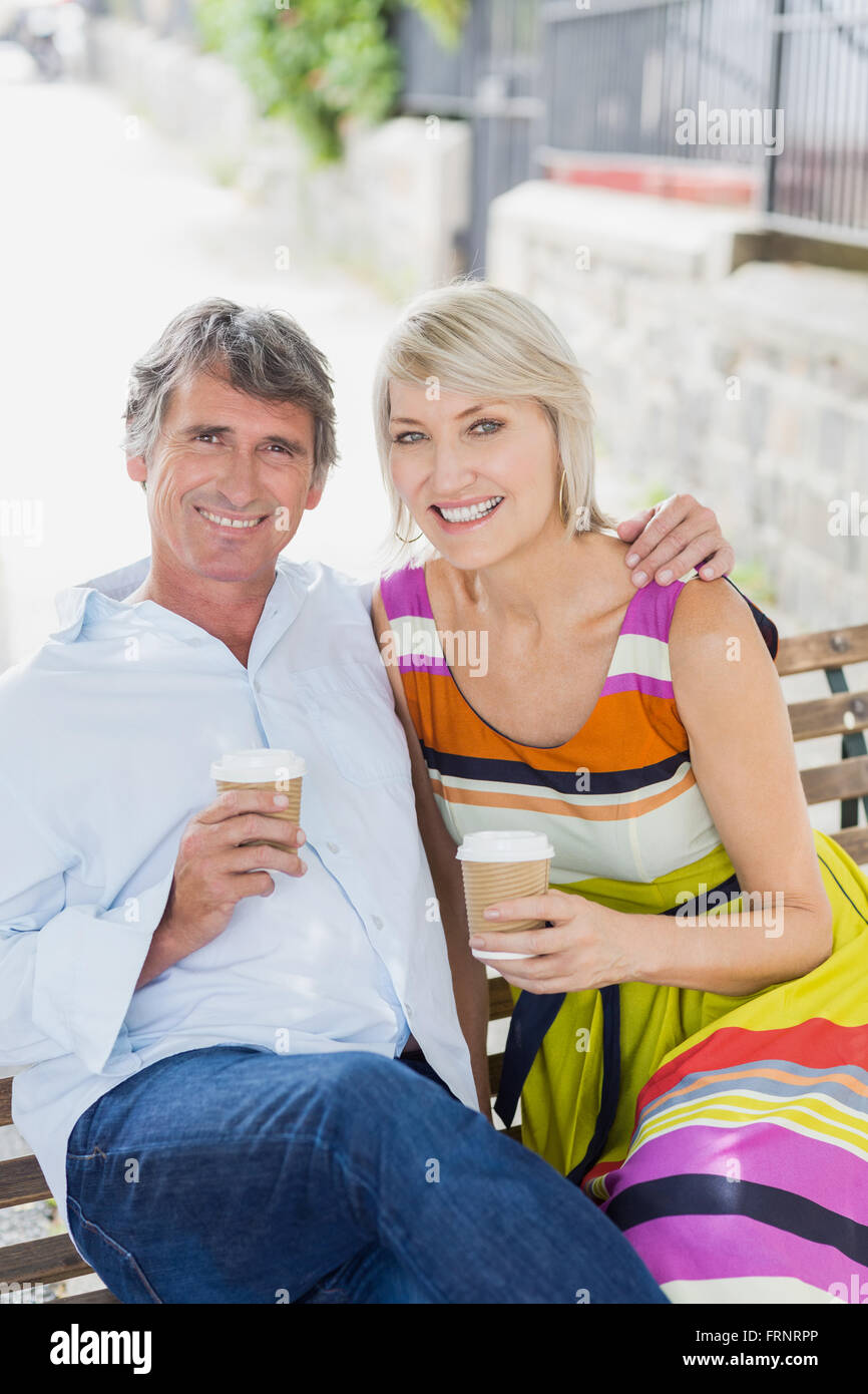 Porträt des Paares mit Kaffee auf Bank Stockfoto