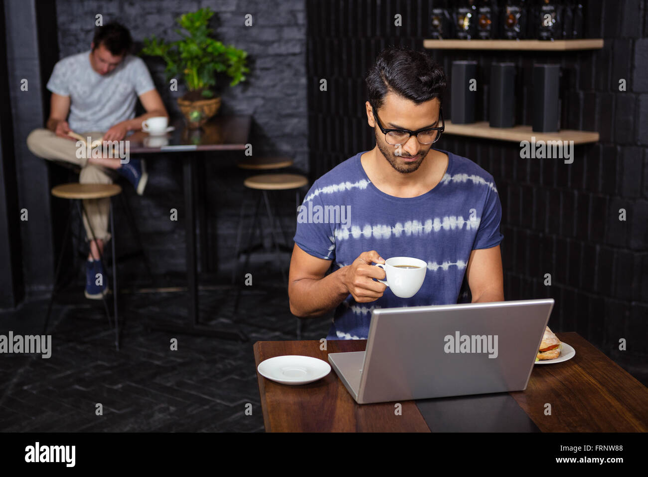 Mann mit Laptop und Kaffee trinken Stockfoto