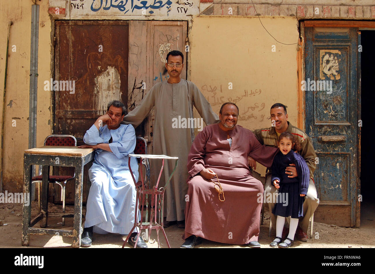 Eine ägyptische Familie tragen traditionelle Galabeyas Pose für ein Foto auf der Straße mit der Kulisse der alten Türen und Wände, Stockfoto