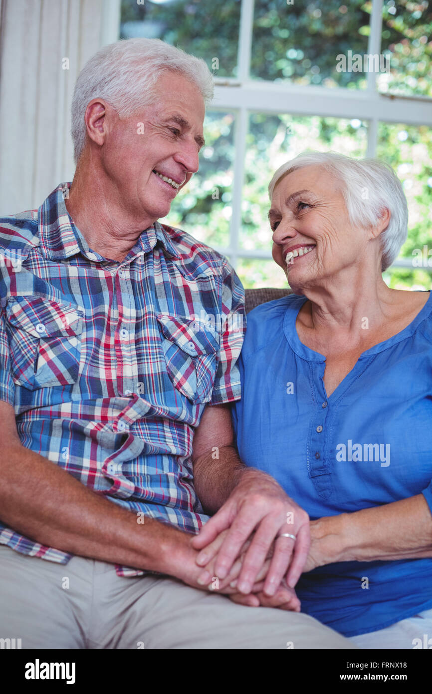 Älteres Paar Hand in Hand zu Hause lächelnd Stockfoto