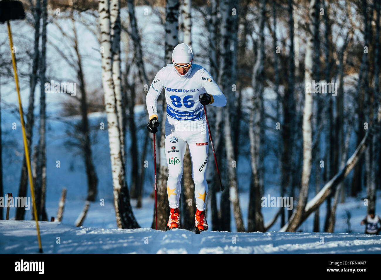 junge männliche Skifahrer während der Rennen im Wald bergauf in Meisterschaft von Tscheljabinsk im Langlauf Stockfoto