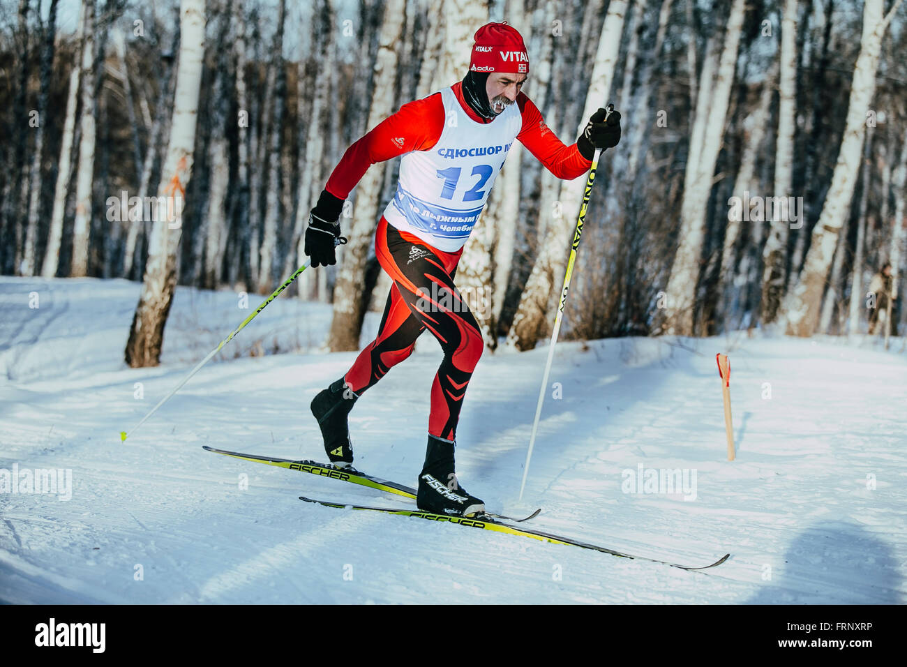 der klassische Stil im Winterwald auf Sportplatz, Frost auf seinen Schnurrbart während der Meisterschaft im mittleren Alter männlicher Skifahrer Stockfoto