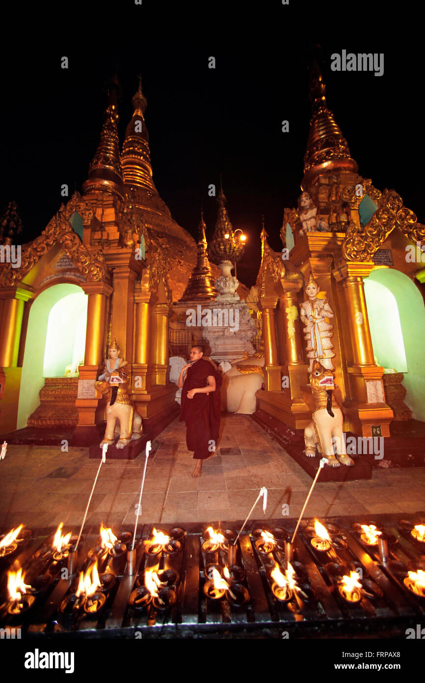 Mönch im Tempel, vorne Angebote Kerze. Mandalay Myanmar Stockfoto