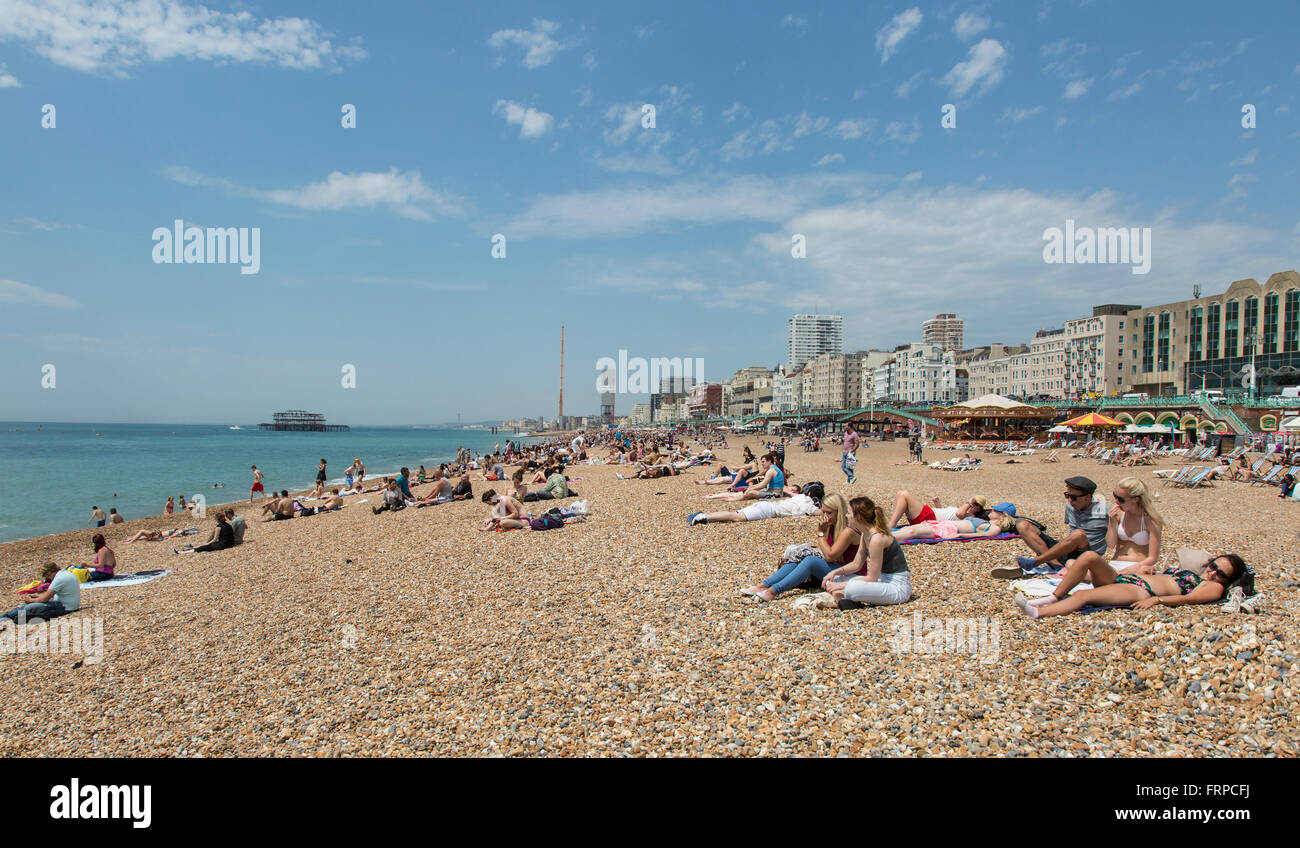 Menschen, die zum Sonnenbaden am Strand von Brighton und Hove, UK Stockfoto