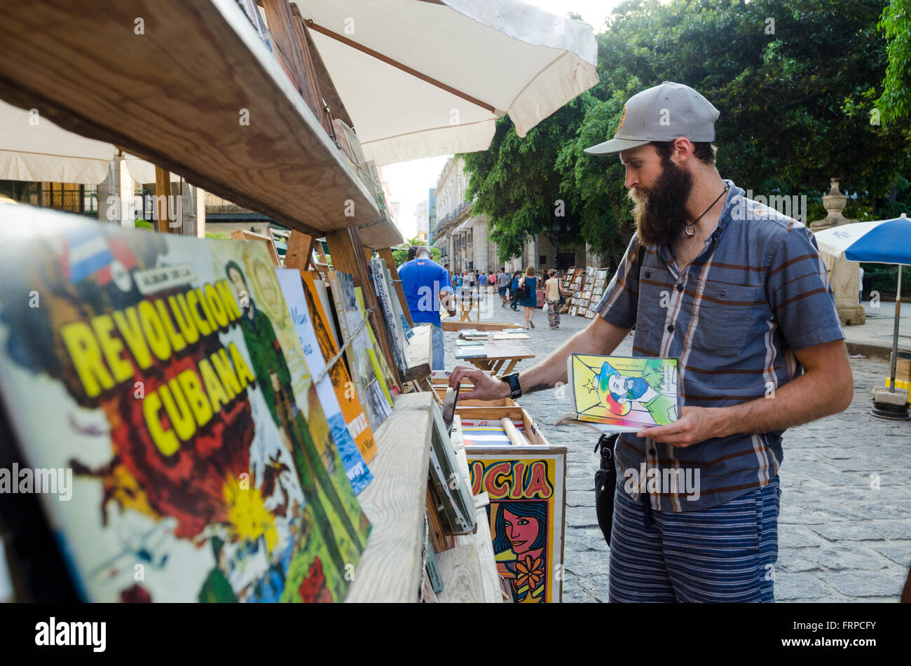 Ein junger Mann schaut Vintage Bücher auf den Straßen in Havanna, Kuba. Stockfoto