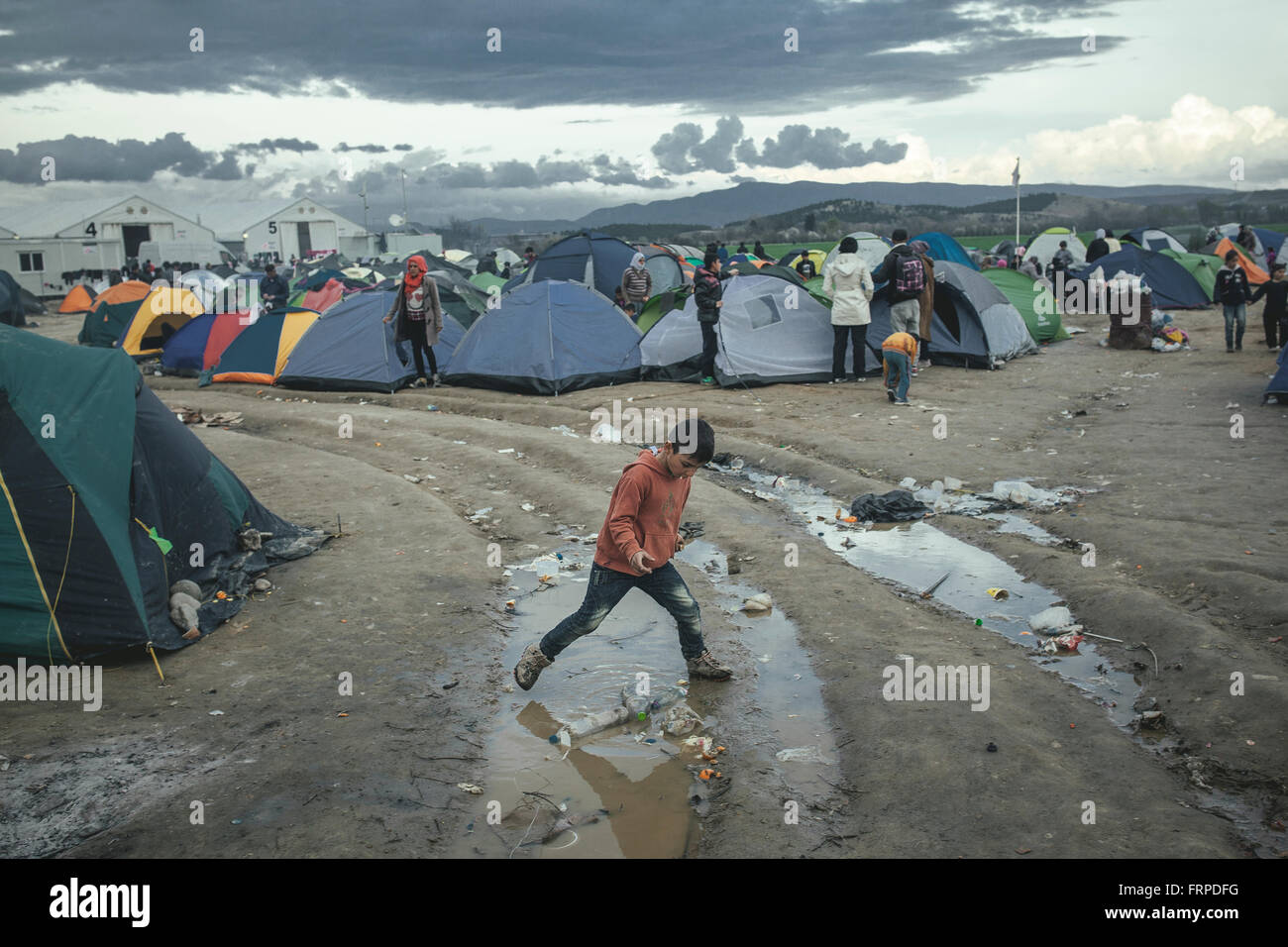 Idomeni Flüchtlingslager an der Grenze griechisches Mazedonien, ein Junge spielt nach starken Regenfällen, Idomeni, Zentralmakedonien, Griechenland Stockfoto