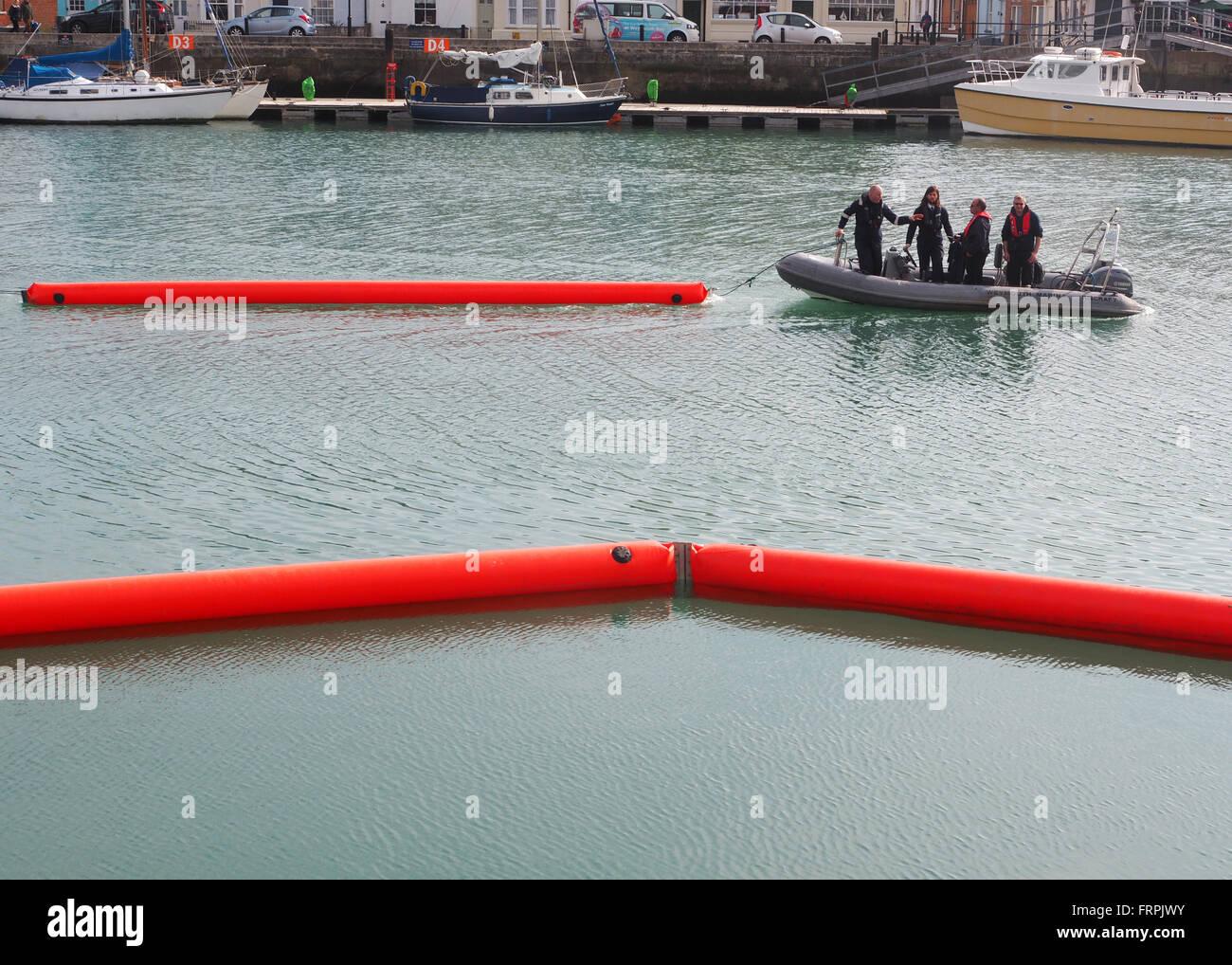Öl Verschmutzung Containment Boom Bereitstellung Übung am Hafen von Weymouth, Dorset, Großbritannien Stockfoto