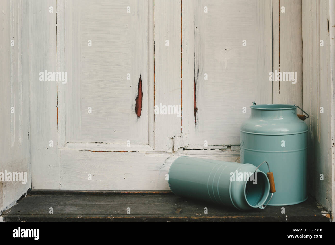 Vintage blaue Milch Kanister vor rustikale Tür. Stockfoto