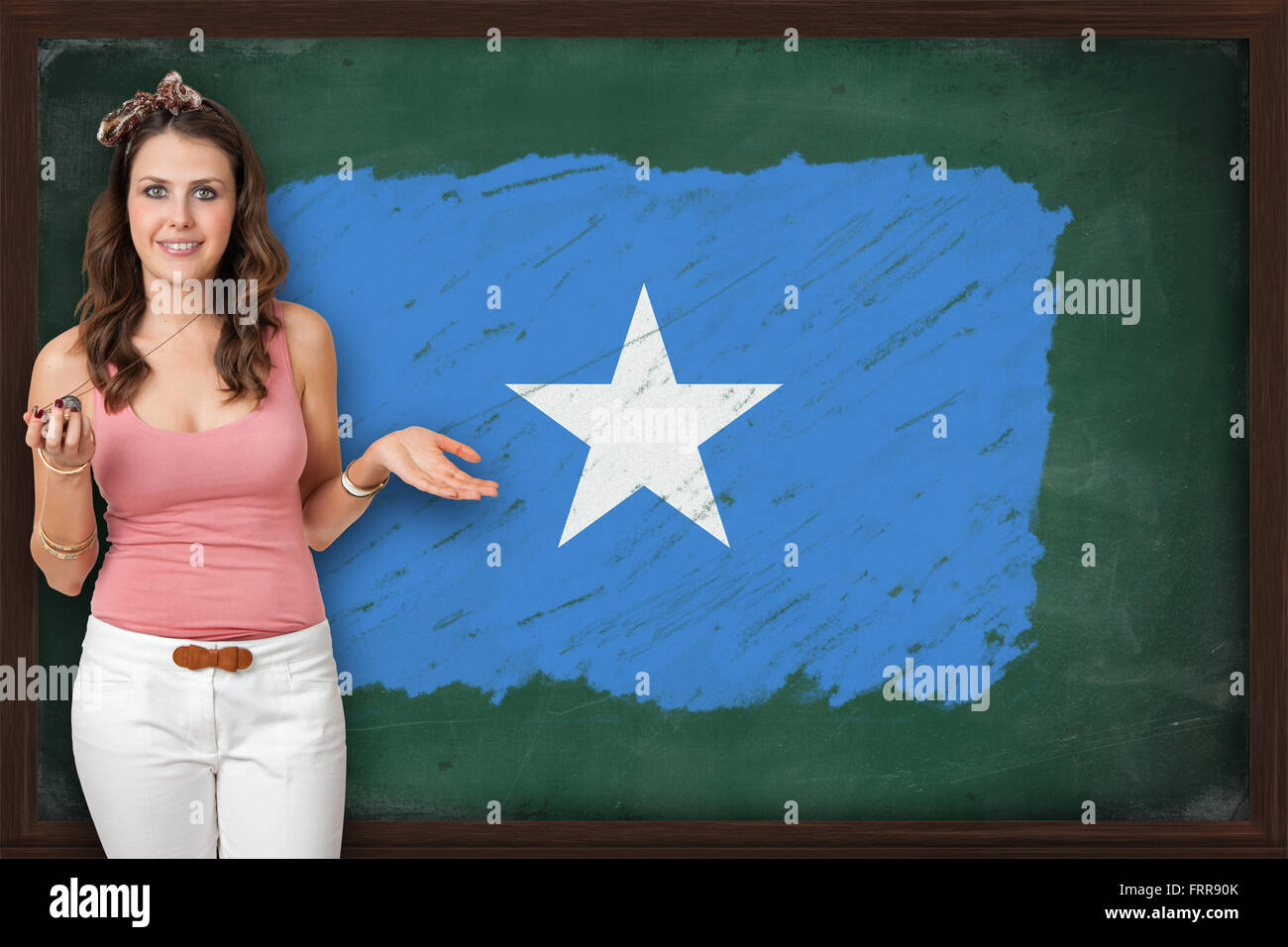 Schöne und lächelnde Frau zeigt Flagge Somalias auf Tafel, Präsentation für Tourismus und marketing-Forschung Stockfoto