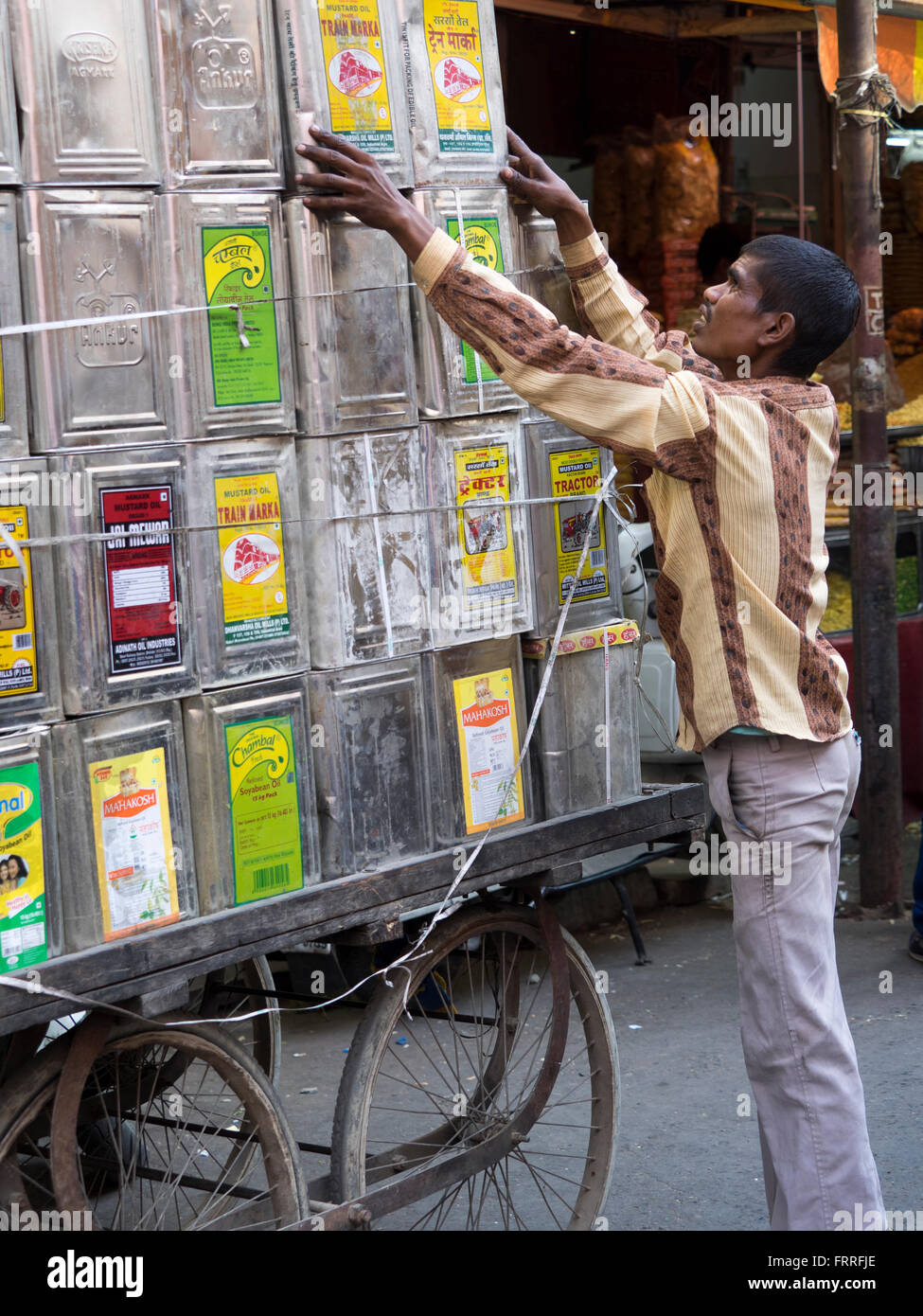 Mann, die Vermittlung von Containern auf Wagen in Udaipur, Rajasthan, Indien Stockfoto