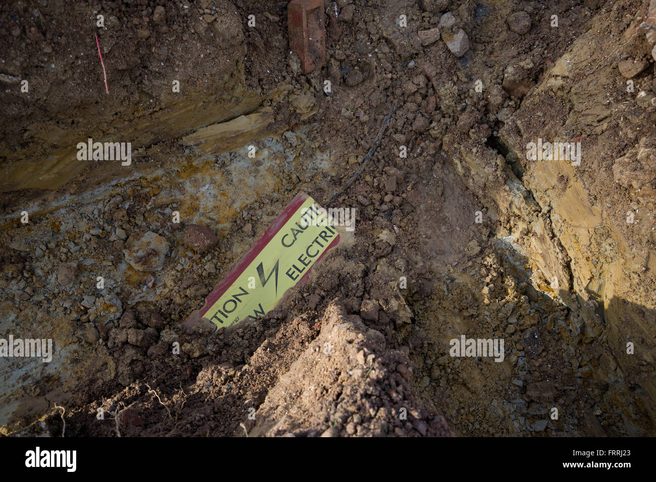 Unterirdische Stromkabel mit Sicherheit Band gelegt über den Rand zu zeigen, wo es ist. Stromkabel im Graben. Stockfoto