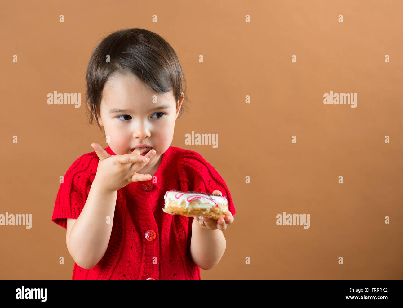 Süßes Kind Mädchen essen süße Krapfen Stockfoto