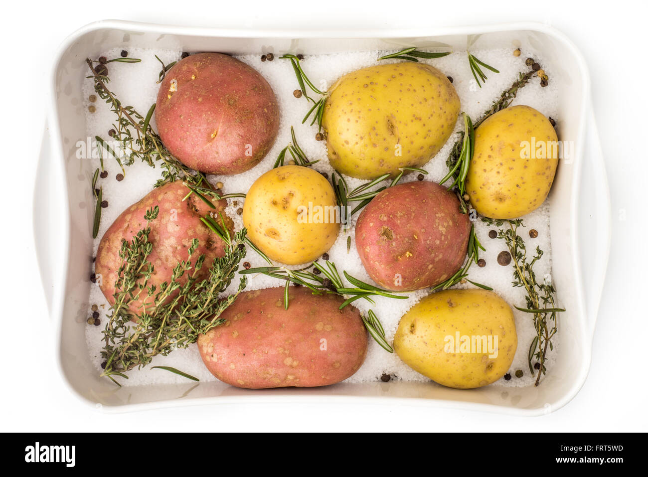 Rohe Kartoffeln mit Gewürzen und Kräutern in der Backing-Schale Stockfoto