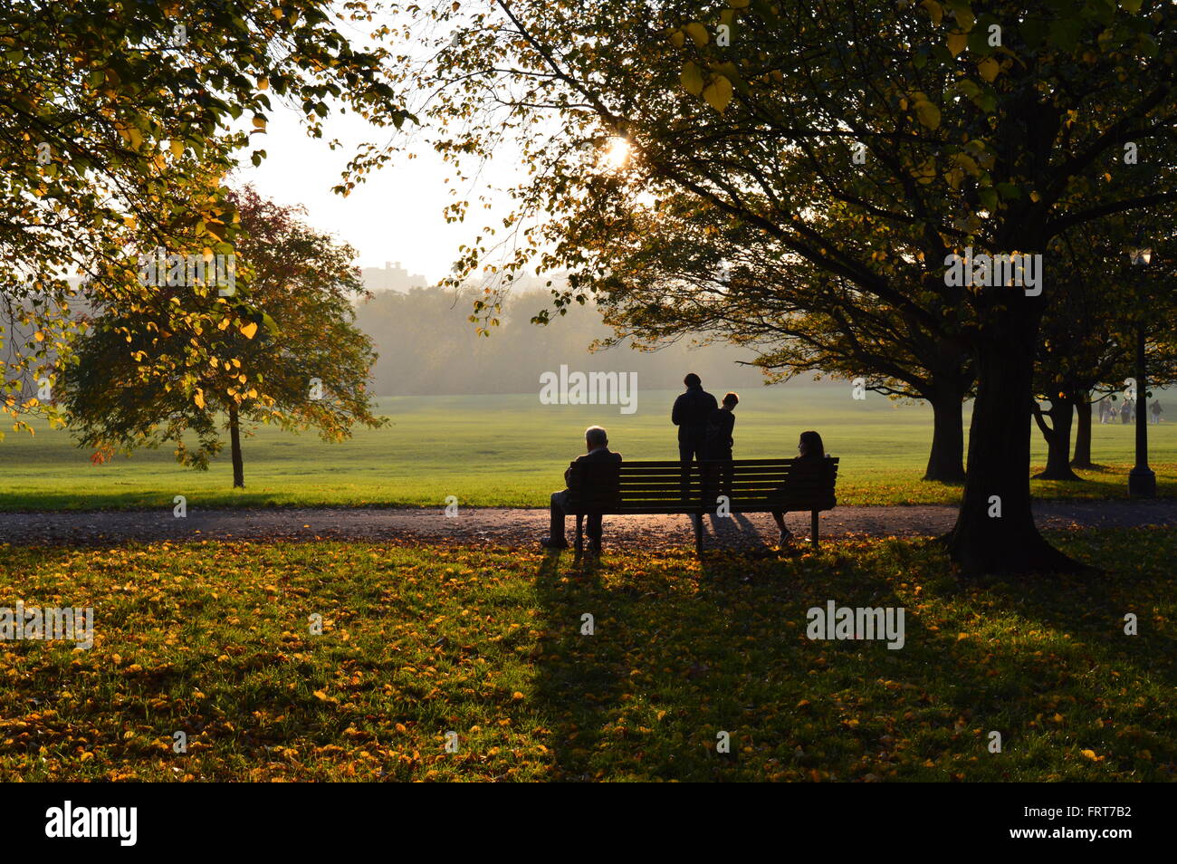 Menschen genießen die späte Nachmittagssonne im Londoner Primrose Hill Park Stockfoto