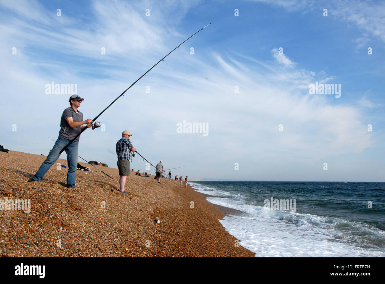 Fischer am Strand mit Stangen Stockfoto