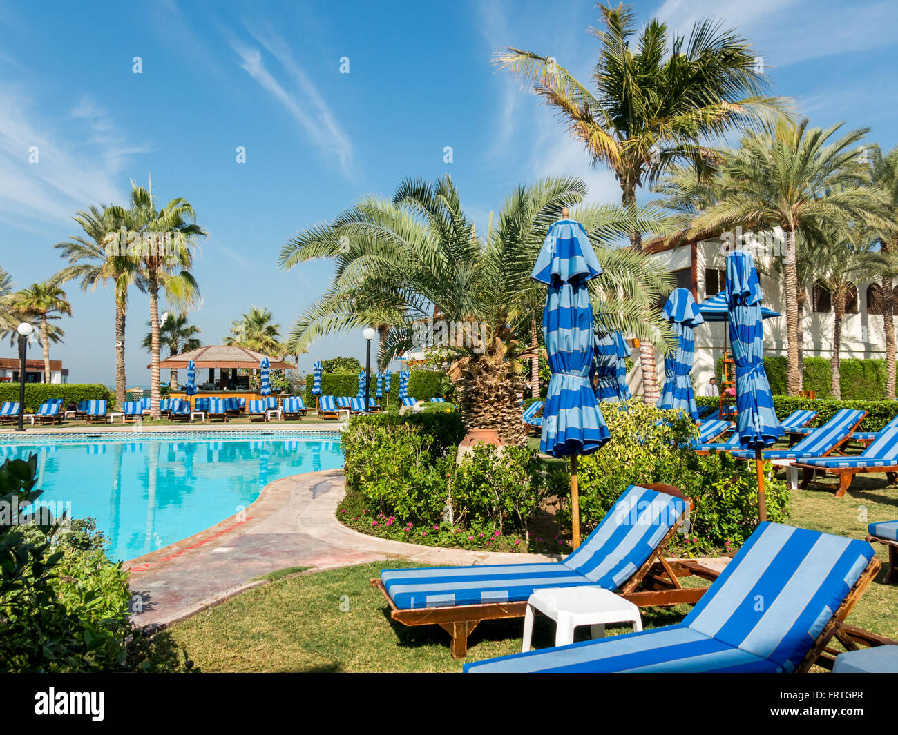 Liegestühlen, Palmen und Pool im tropischen Garten der Luxus Hotel Beach Resort in Dubai, Vereinigte Arabische Emirate Stockfoto