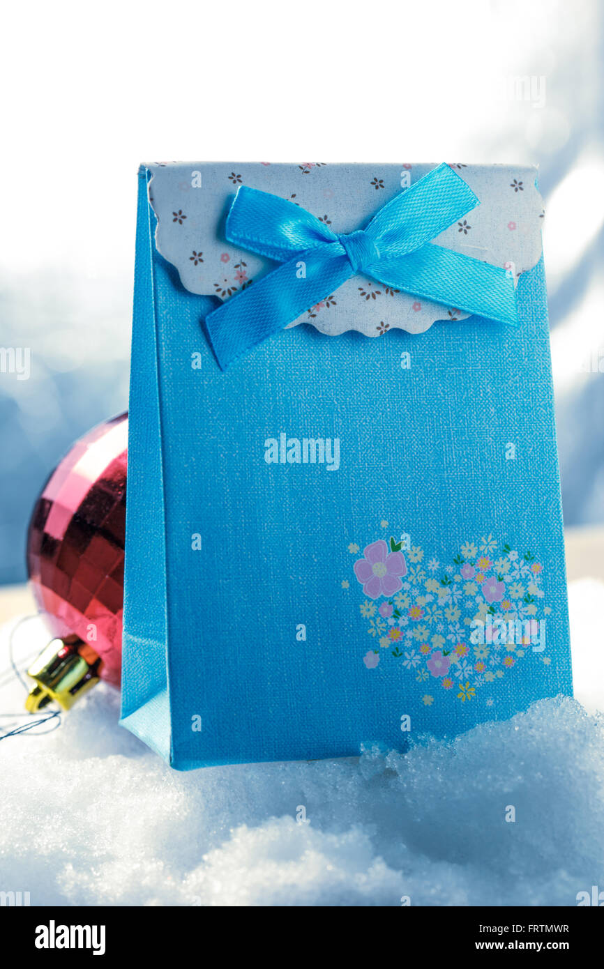 Rote von Weihnachtskugel mit Geschenk-Box auf dem weißen Schnee Stockfoto