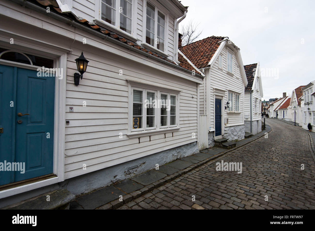 Alte weiße Holzhäuser auf gepflasterten Gassen in der Altstadt in Stavanger, Norwegen. Stockfoto