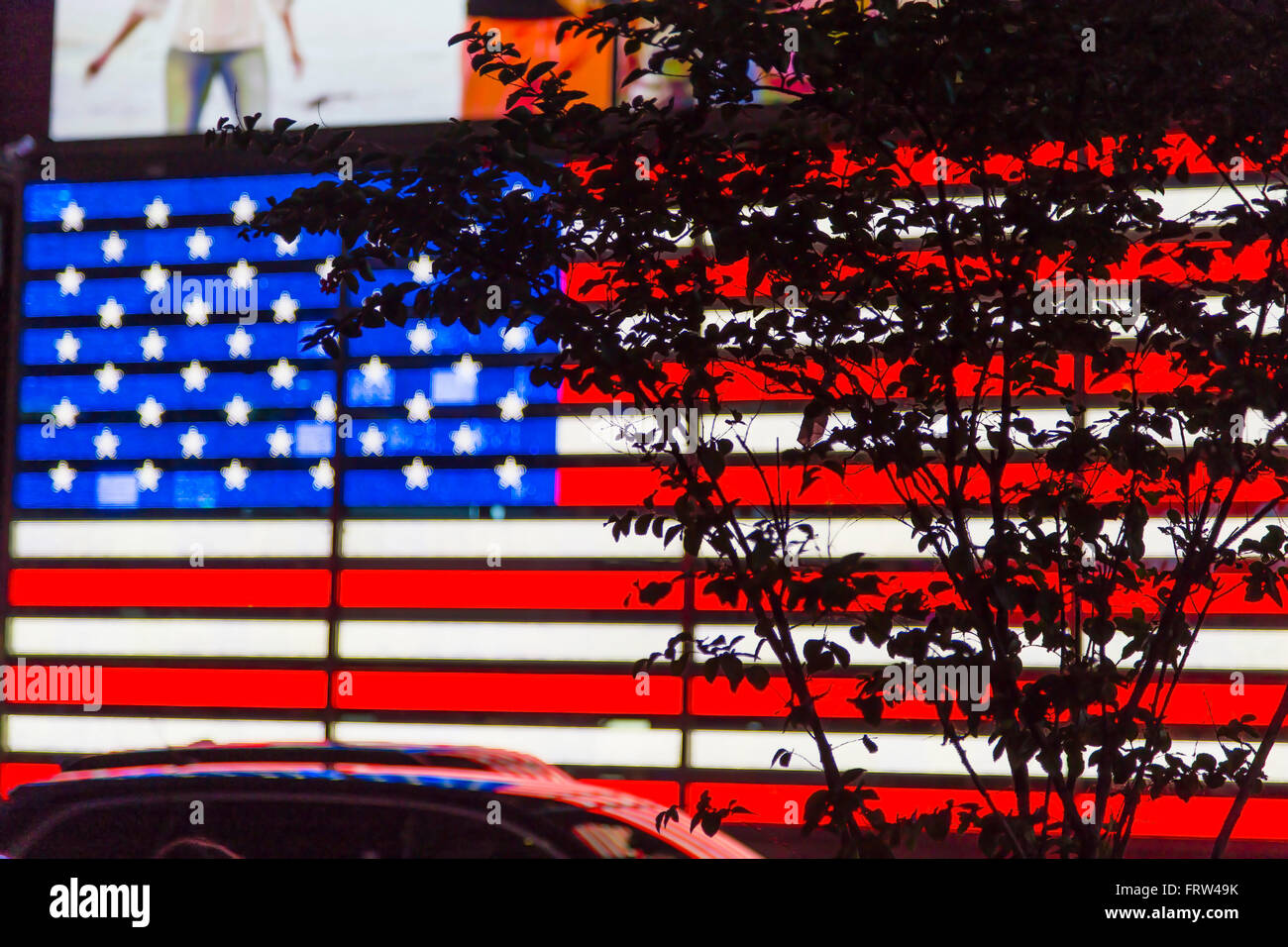 Times Square mit der amerikanischen Flagge LED Schild, Auto-Silhouetten und  Taxi Taxis in Manhattan, New York City Stockfotografie - Alamy