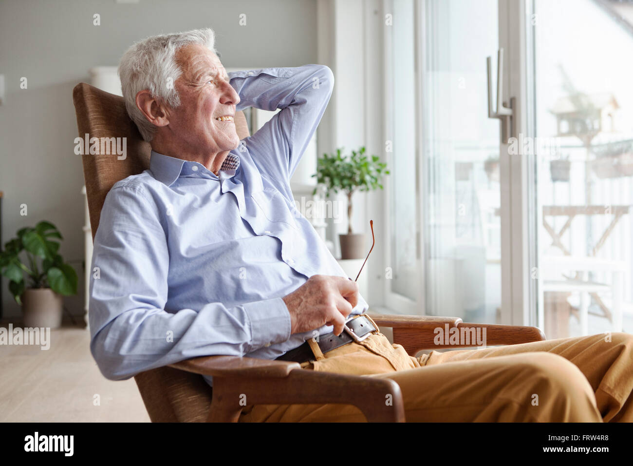 Porträt von senior woman am Sessel zu Hause entspannen Stockfoto