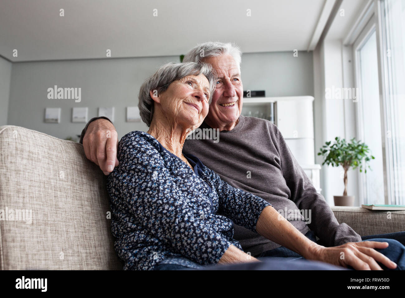 Gerne älteres paar sitzen zusammen auf der Couch im Wohnzimmer Stockfoto
