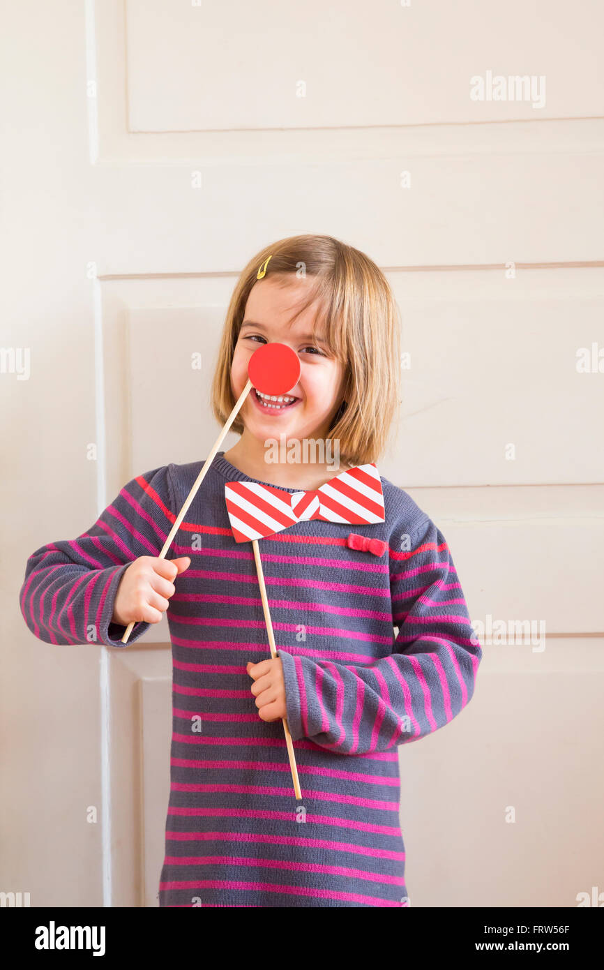 Porträt von kleinen Mädchen mit roter Nase und Spielzeug Bogen Stockfoto