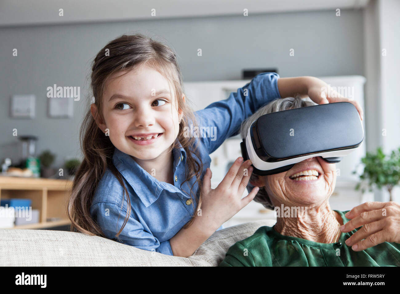 Ältere Frau und ihre Enkelin Spaß mit Virtual-Reality-Brille zu Hause Stockfoto