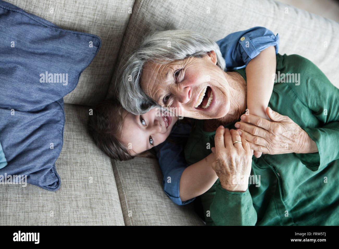 Porträt des Lachens Großmutter und Enkelin auf der couch Stockfoto