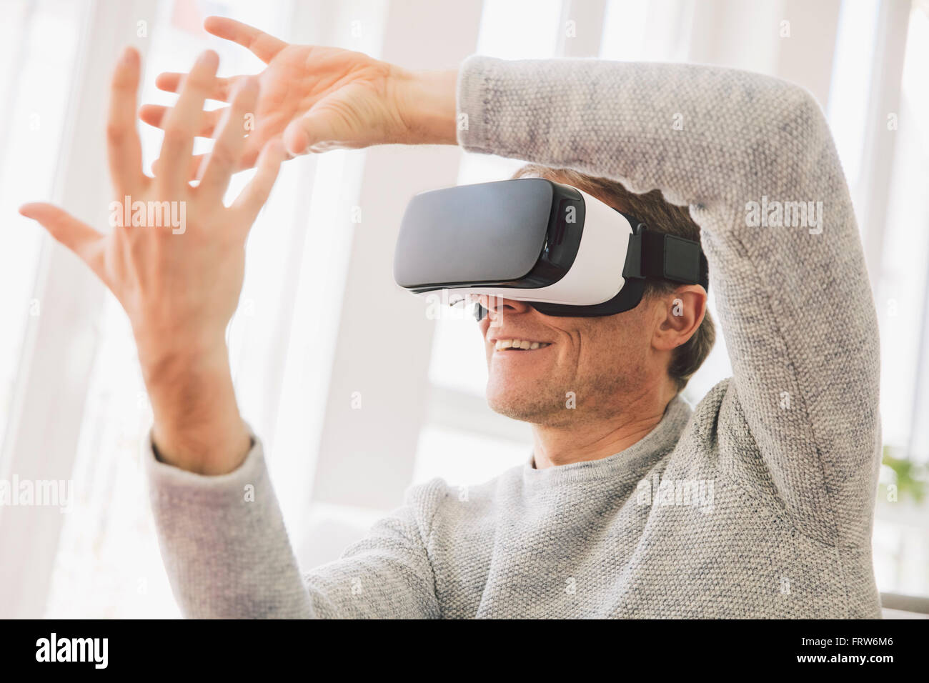 Mann mit virtual-Reality-Brille mit seinen Händen Stockfoto