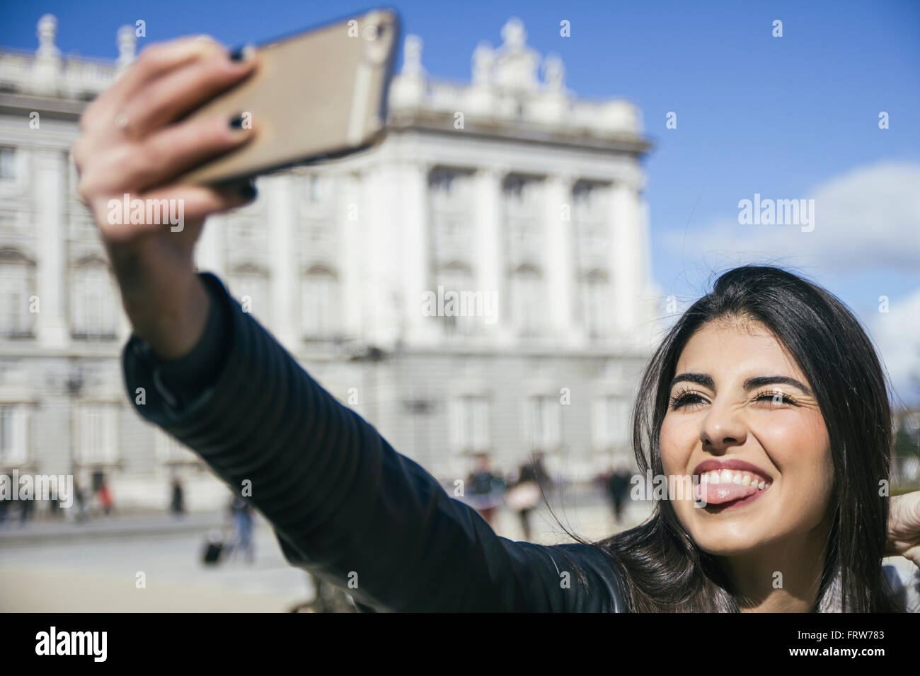 Spanien, Madrid, Portrait Frau Grimassen während der Einnahme ein Selbstporträt mit smartphone Stockfoto