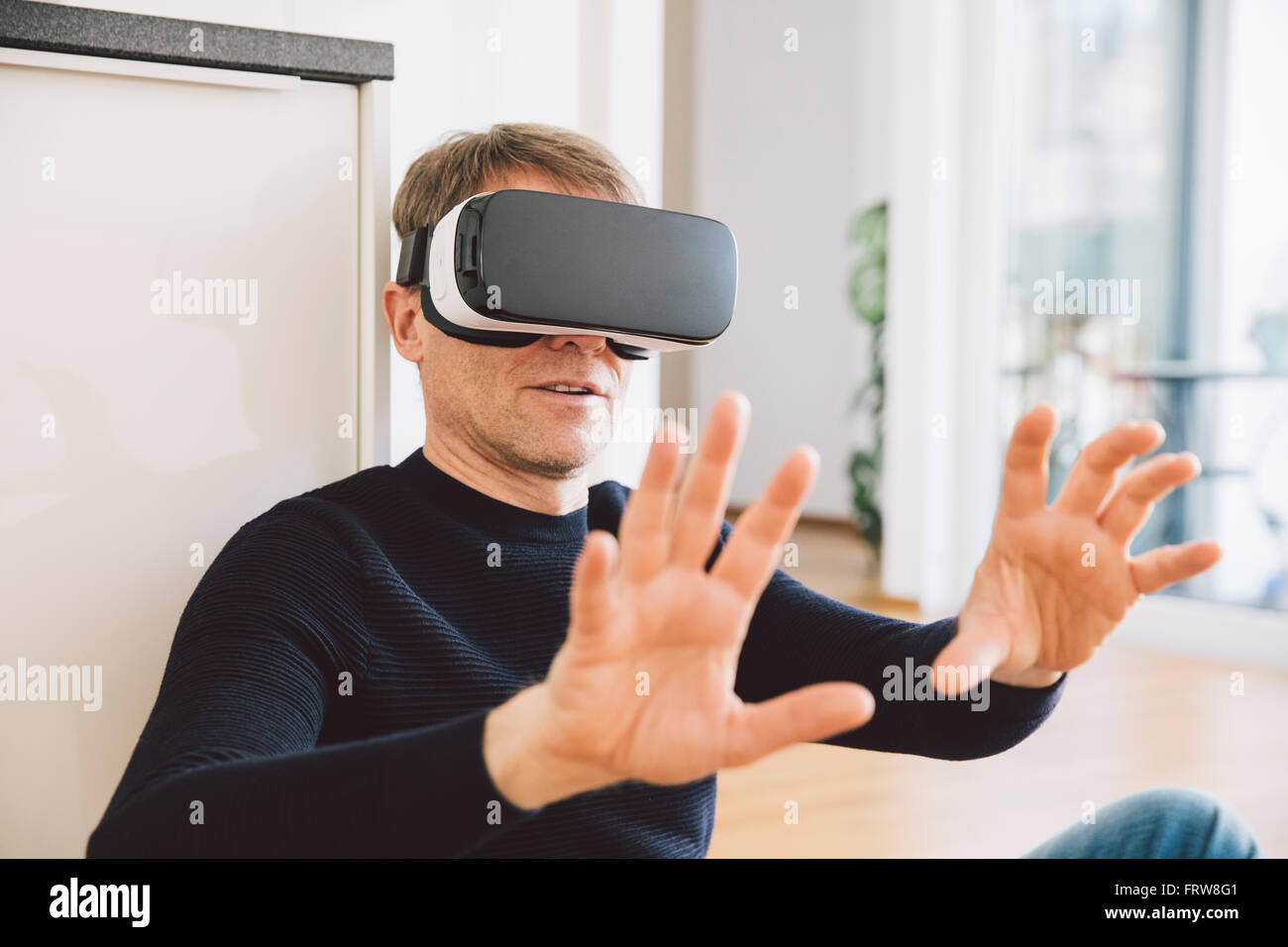 Mann mit virtual-Reality-Brille mit seinen Händen Stockfoto